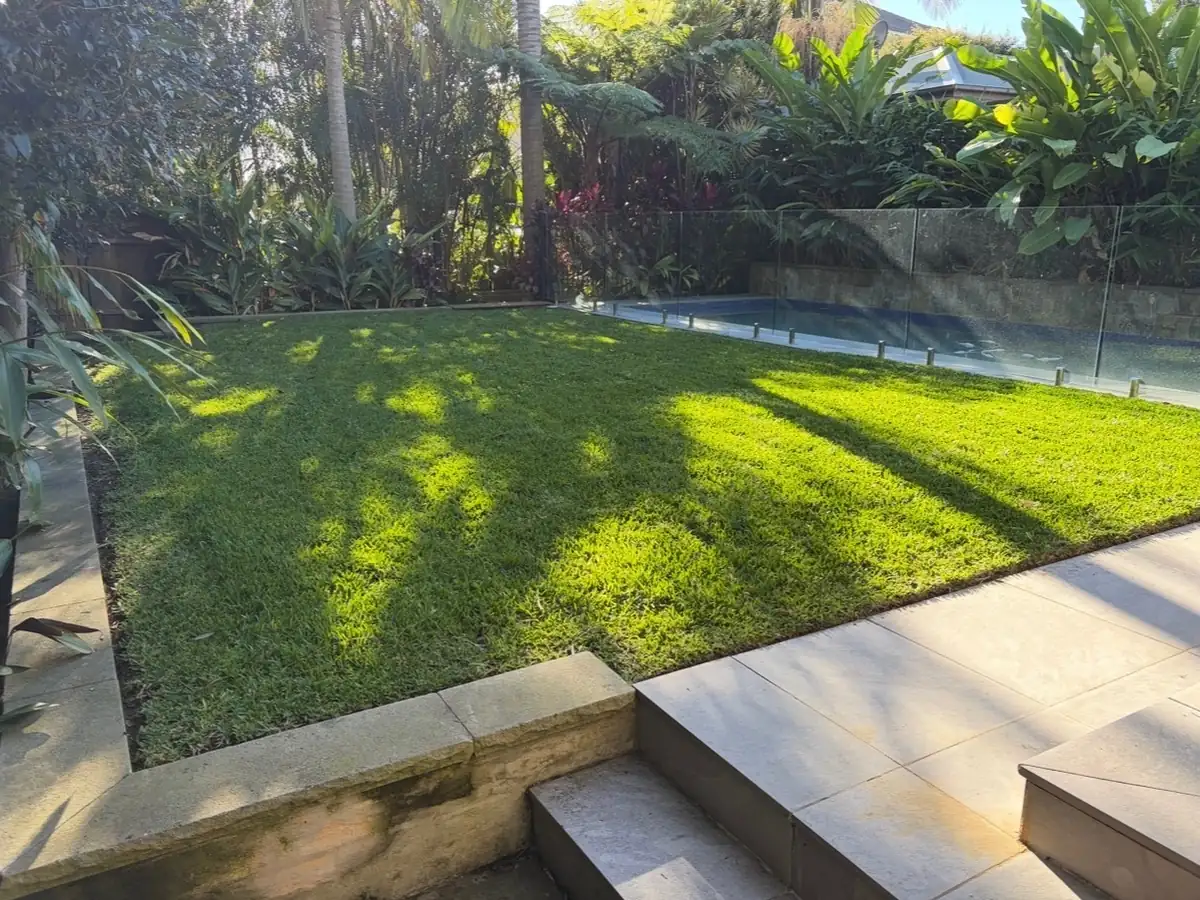 The same poolside lawn after mowing, short and even with crisp edges
